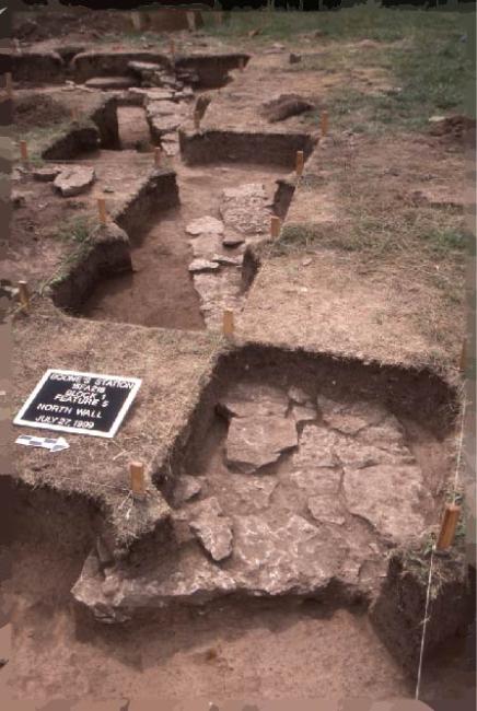 Series of excavated archaeological units uncovering a buried historic wall